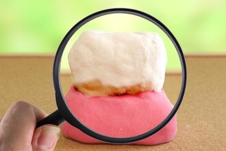 歯の模型を虫眼鏡で拡大している