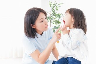 歯科衛生士にお口の中を見せる少女