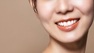 白い歯を見せて笑う女性の口元