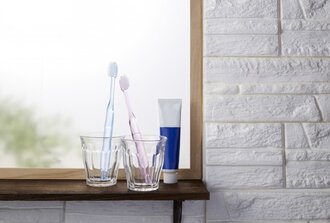 コップに立てて窓辺に置いてある二本の歯ブラシ