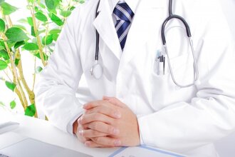 指を組んでいる医師