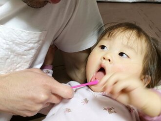 子供の歯を磨いている写真
